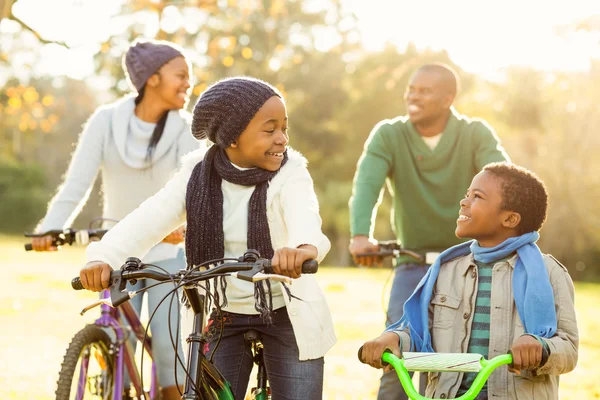 Jeune famille souriante faisant une balade à vélo — Photo