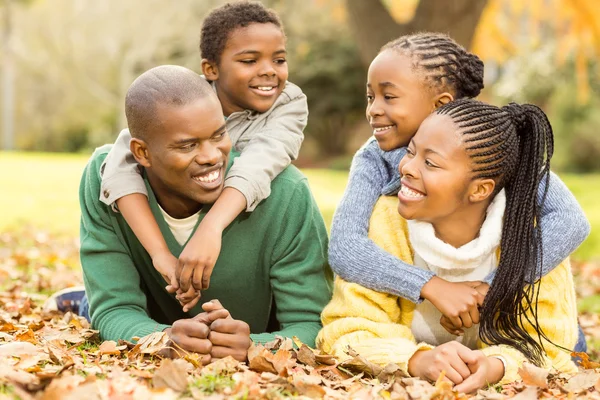 Porträt einer jungen Familie, die im Laub liegt — Stockfoto