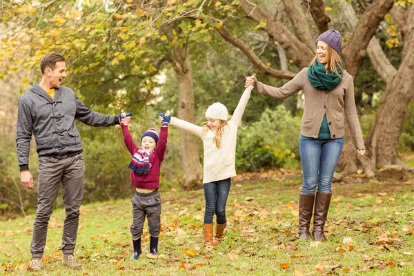 Улыбающаяся молодая семья поднимает руки — стоковое фото