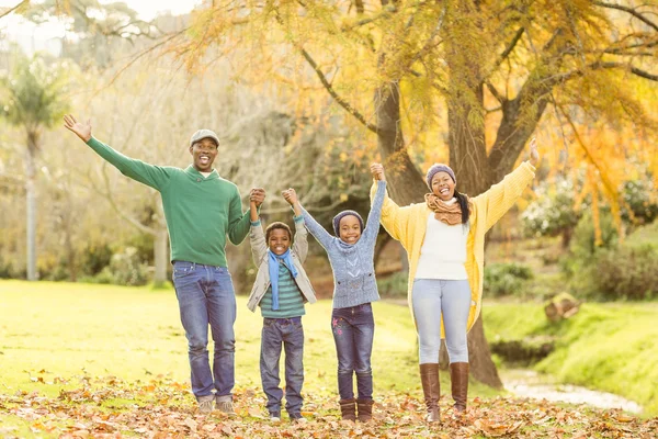 Retrato de una joven familia sonriente con los brazos levantados — Foto de Stock