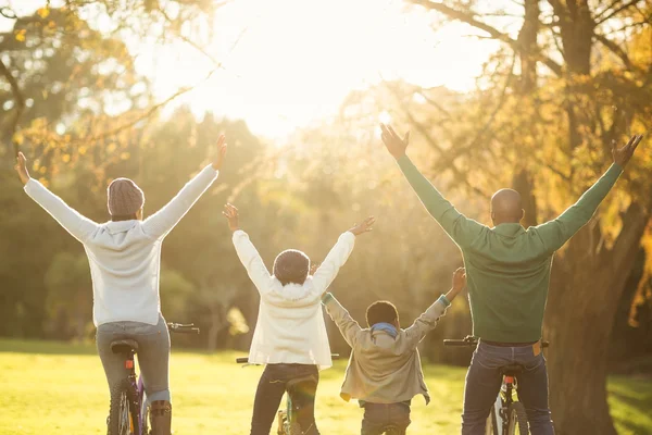 Junge Familie mit erhobenen Armen auf dem Fahrrad — Stockfoto