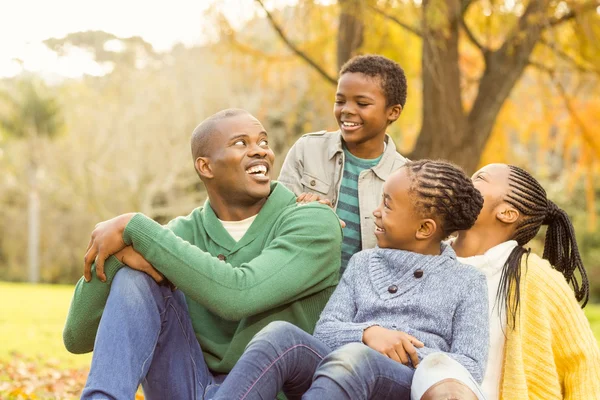Portrait of a young family sitting in leaves — Stock Photo, Image