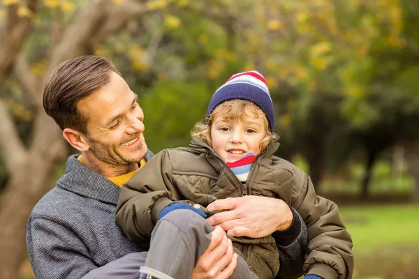 Junger Vater hebt seinen kleinen Sohn in Park — Stockfoto