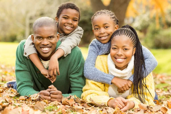 Portret van een jong gezin liggen bladeren — Stockfoto