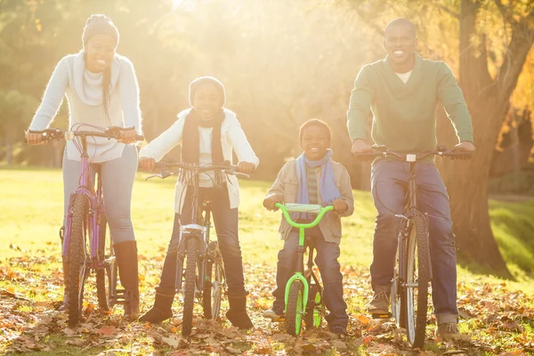 Joven familia sonriente haciendo un paseo en bicicleta — Foto de Stock