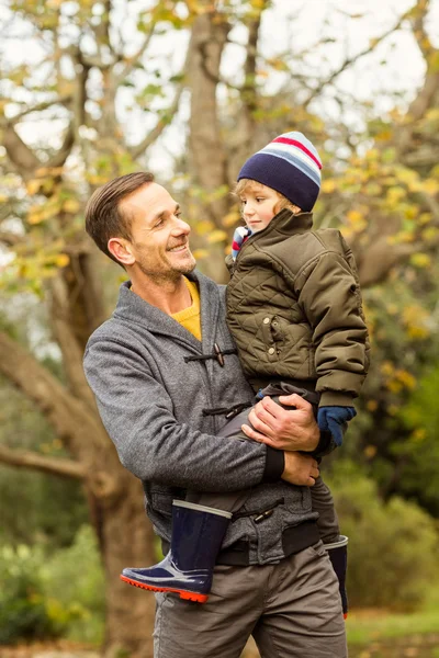 Junger Vater hebt seinen kleinen Sohn in Park — Stockfoto
