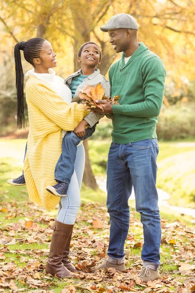 Porträt einer jungen lächelnden Familie mit Blättern — Stockfoto