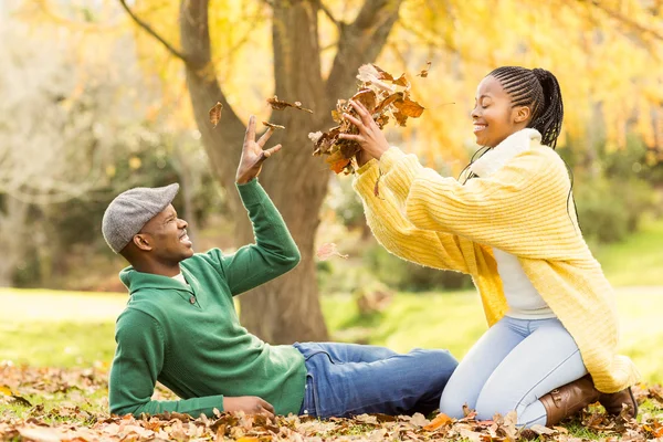 Vista de una joven pareja sonriente en hojas — Foto de Stock