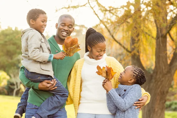 Retrato de uma jovem família sorridente segurando folhas — Fotografia de Stock