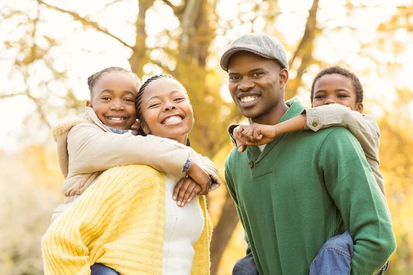 Retrato de una joven familia sonriente a cuestas — Foto de Stock