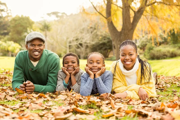 Portret młodej rodziny uśmiechający się leżącego liście — Zdjęcie stockowe