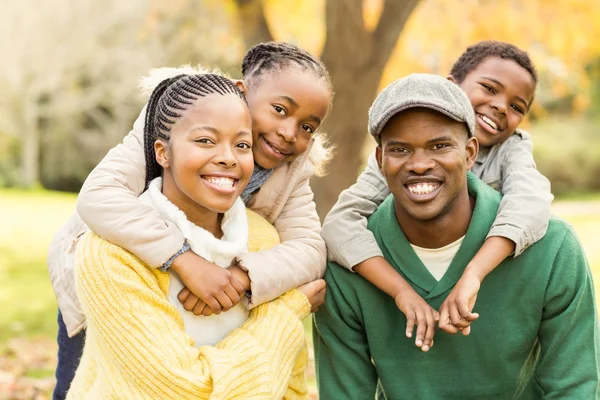Retrato de una joven familia sonriente a cuestas — Foto de Stock