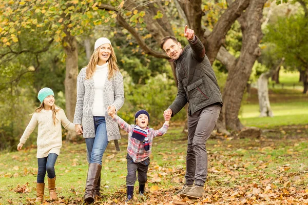 Молодая семья бегает в листьях — стоковое фото