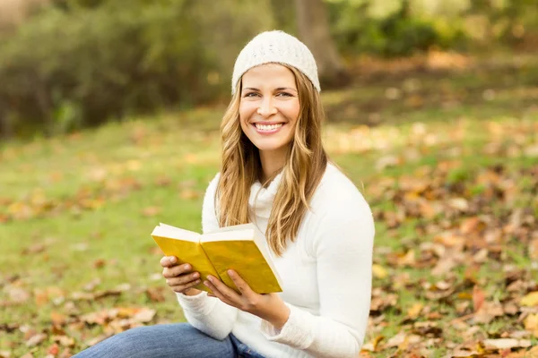 Portrait d'une jolie femme souriante lisant un livre — Photo