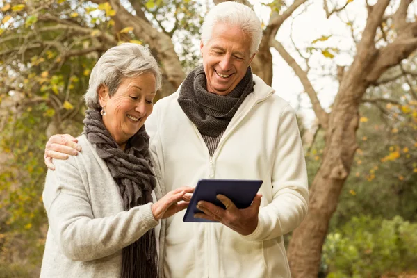 Seniorenpaar im Park mit Tablet — Stockfoto