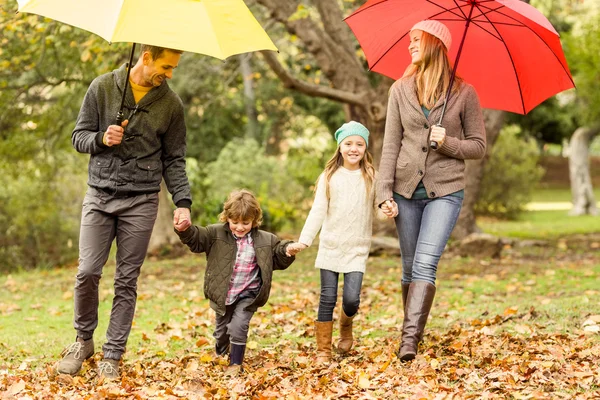 Souriant jeune famille sous parapluie — Photo