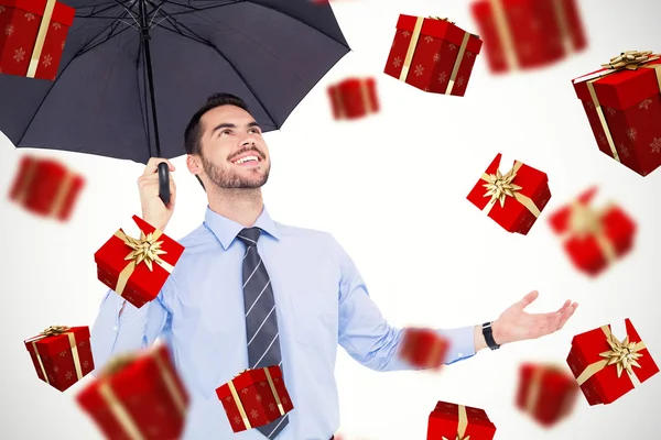Счастливый бизнесмен укрывается с черным зонтиком — стоковое фото