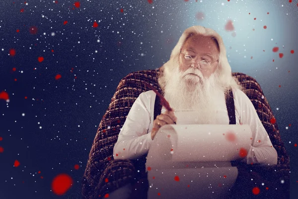 Composite image of father christmas writing list with a quill — Stock Photo, Image