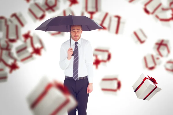 Biznesmen stojąc pod czarny parasol — Zdjęcie stockowe