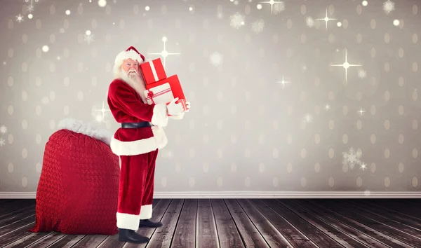 Santa claus carrying pile of gifts — Stock Photo, Image