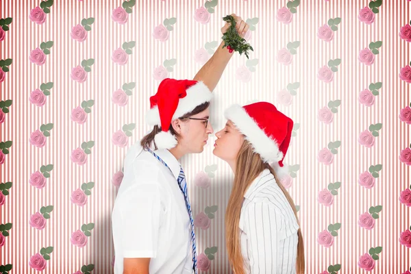 Geeky hipster kissing under mistletoe — Stock Photo, Image