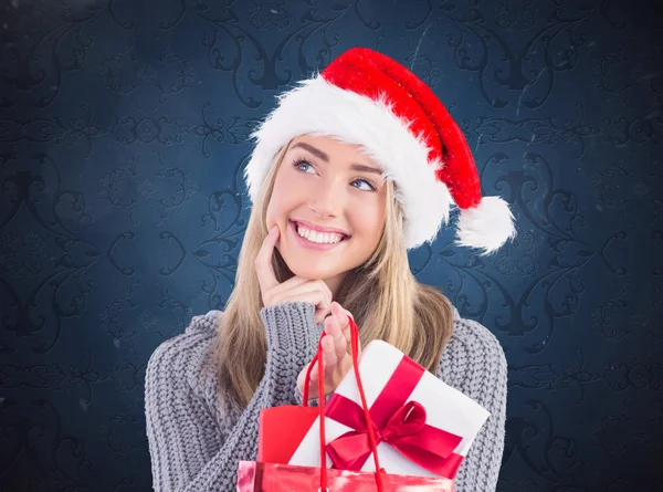 Blondine hält Weihnachtsgeschenk und Tasche in der Hand — Stockfoto