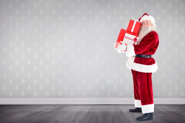 Zusammengesetztes Bild des Weihnachtsmannes, der Geschenke trägt — Stockfoto