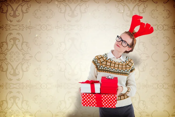 Thoughtful geeky hipster holding presents — Stock Photo, Image