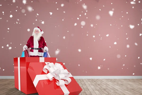 Samengestelde afbeelding van santa staande in grote gave — Stockfoto