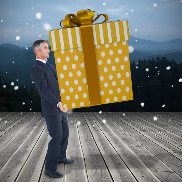 Immagine composita di uomo elegante con regalo gigante — Foto Stock