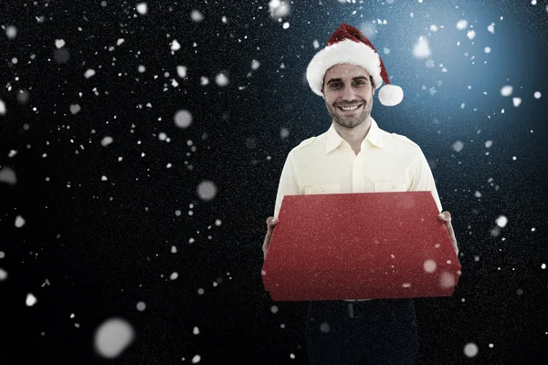 Hombre vistiendo sombrero de santa mientras sostiene rojo — Foto de Stock