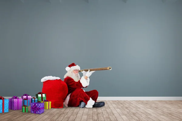 Samengestelde afbeelding van santa op zoek via telescoop — Stockfoto