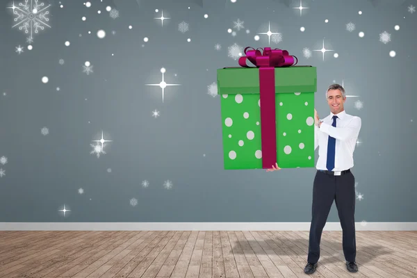 Immagine composita di uomo elegante con regalo gigante — Foto Stock