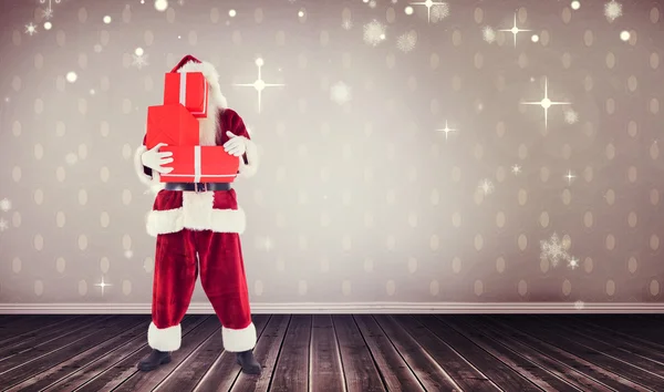 Composite image of santa carrying gifts — Stock Photo, Image