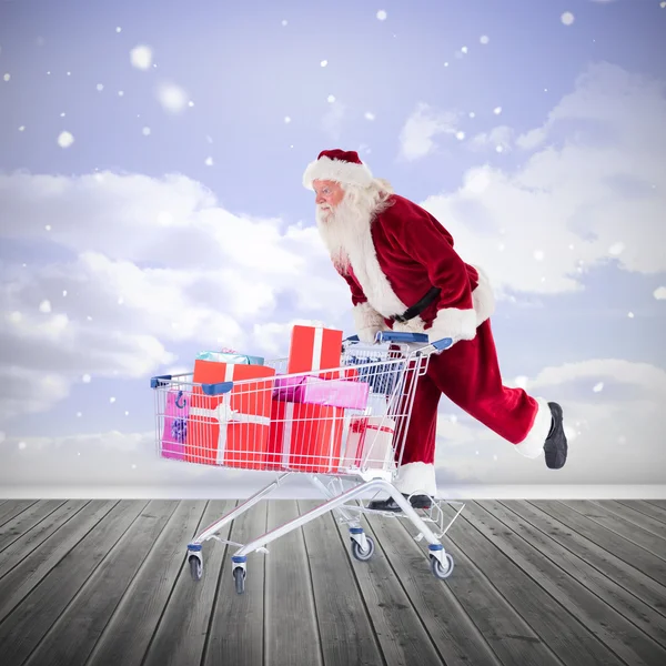 Immagine composita di Babbo Natale spingendo un carrello — Foto Stock