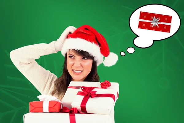 Brunette scratching head and holding gifts — Stock Photo, Image