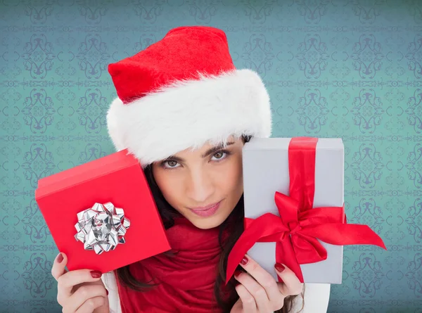 Composite image of cheerful brunette holding christmas gifts — Stock Photo, Image