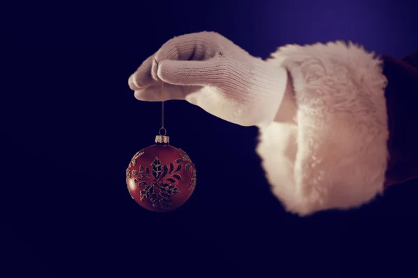 Santas hand håller en jul lampa — Stockfoto