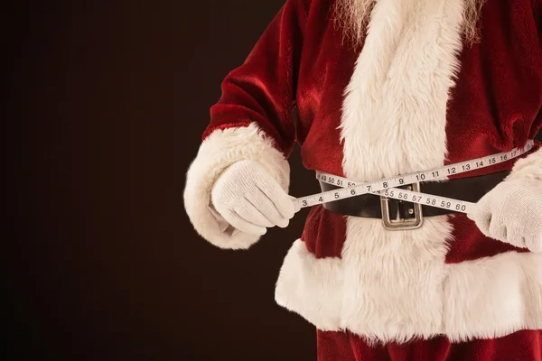 Santa Claus měří jeho břicho — Stock fotografie