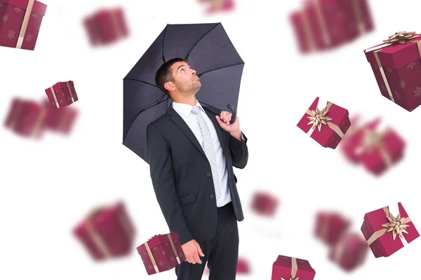 Zakenman sheltering onder de paraplu van de zwarte — Stockfoto