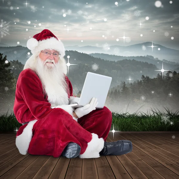 Papai Noel senta e usa um laptop — Fotografia de Stock