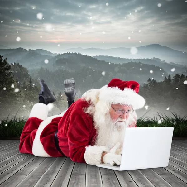 Santa se encuentra frente a su portátil — Foto de Stock