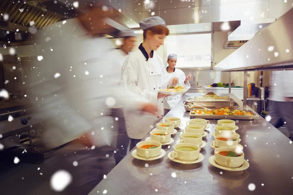 Quatro chefs trabalhando em uma cozinha moderna — Fotografia de Stock