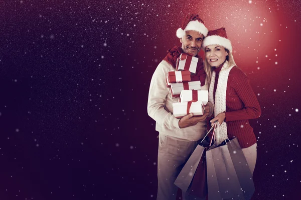 Happy festive couple with gifts and bags — Stock Photo, Image