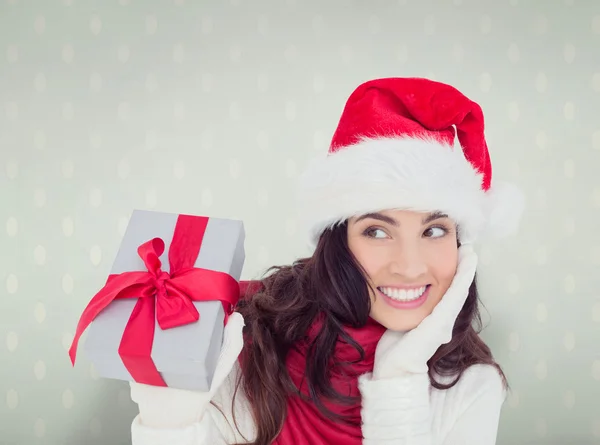 Überraschte Brünette im Weihnachtsmannhut mit Geschenk — Stockfoto
