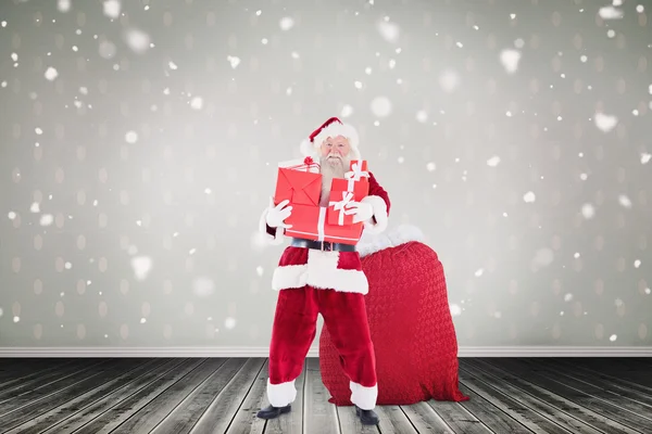 Der Weihnachtsmann hält einen Haufen Geschenke in der Hand — Stockfoto