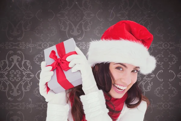 Felice bruna in cappello di Babbo Natale in possesso di regalo — Foto Stock