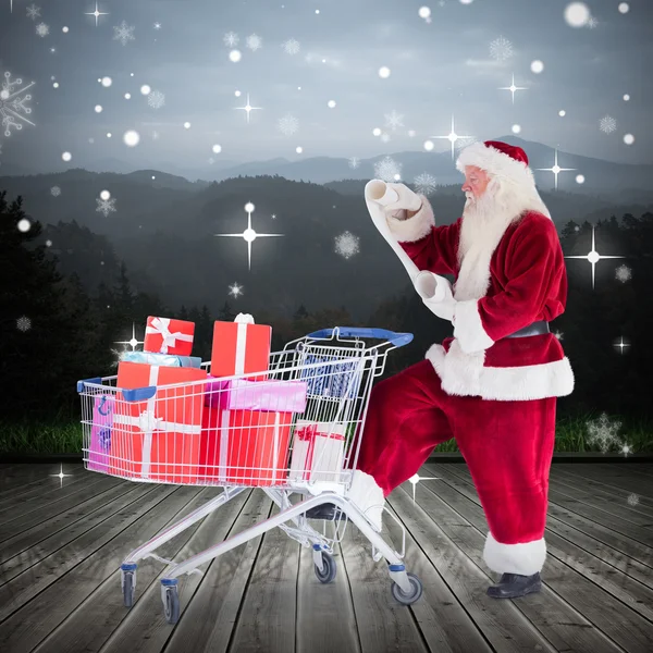 复合图像的圣诞老人送礼物从购物车 — 图库照片