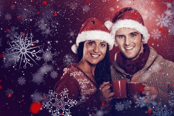 Young festive couple holding mugs — Stock Photo, Image