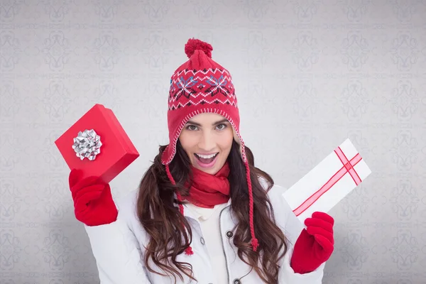 Festive brunette in winter clothes holding gifts — Stock Photo, Image